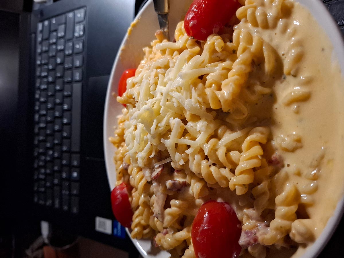 Als de saus klaar is met de gewenste dikte, over de pasta gieten en goed mengen zodat de pasta bedekt wordt. Voeg eventueel nog een klein beetje geraspte kaas bovenop toe.