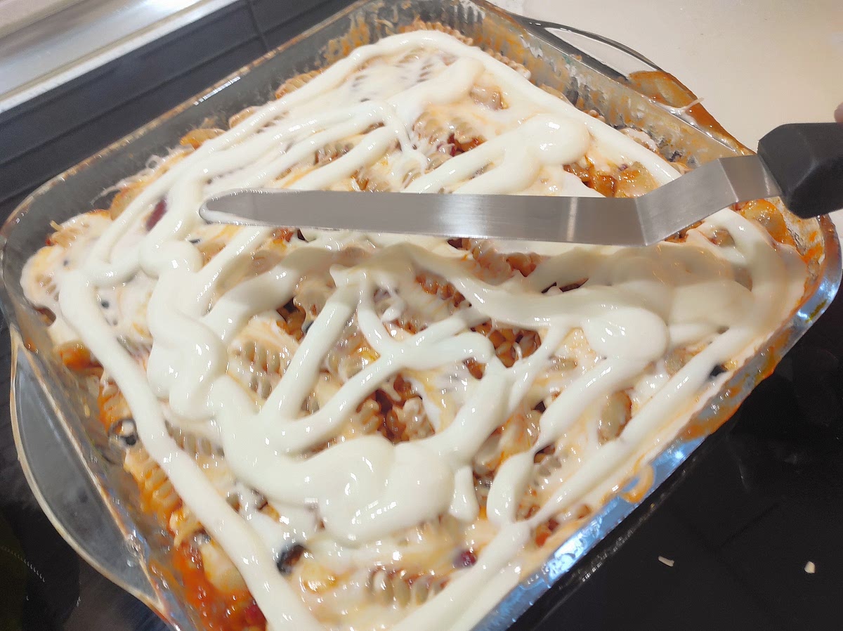 Agregar el resto de la pasta y nuevamente untar con abundante bechamel, espolvorear con mozzarella y luego con una cuchara, el preparado de perejil/grana/pan rallado.