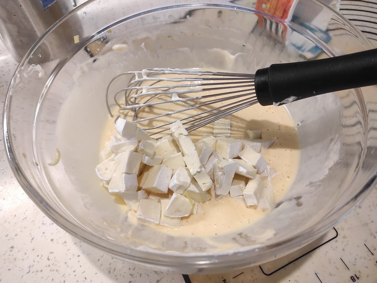 Mientras cuece el puerro, cortar el brie en dados pequeños CON su cáscara. En un bowl, cascar los huevos, batirlos y agregar la nata. Incorporar el queso.