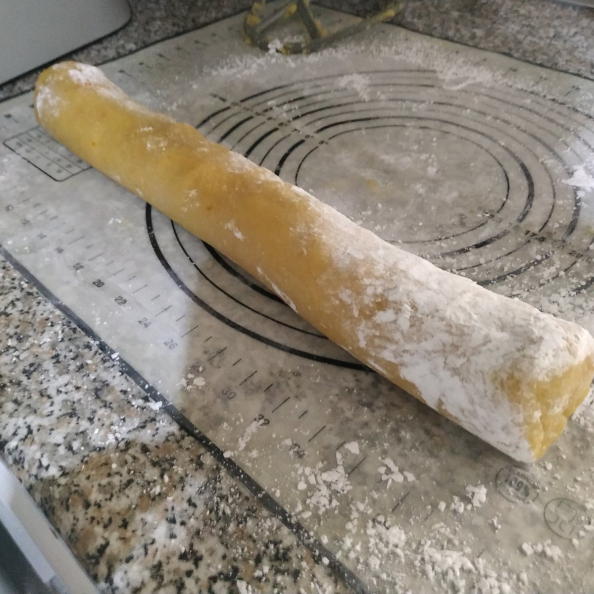 Espolvoreado la encimera con azúcar glas, Formar un cilindro homogéneo y porcionar en 18 partes iguales de 35g aprox cada uno.