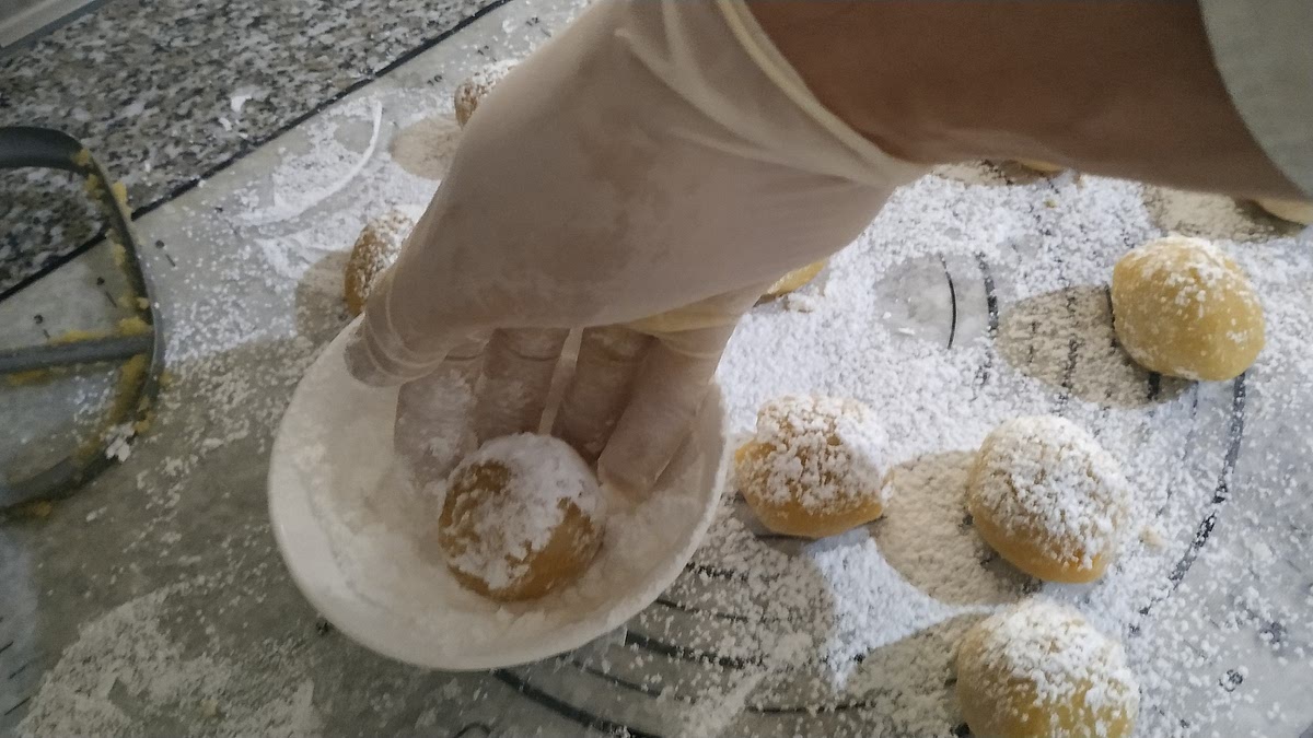 En un cazo mediano colocar el azúcar glas, dar forma de bola a cada porción y luego rebosar cada una haciéndola girar en el azúcar.