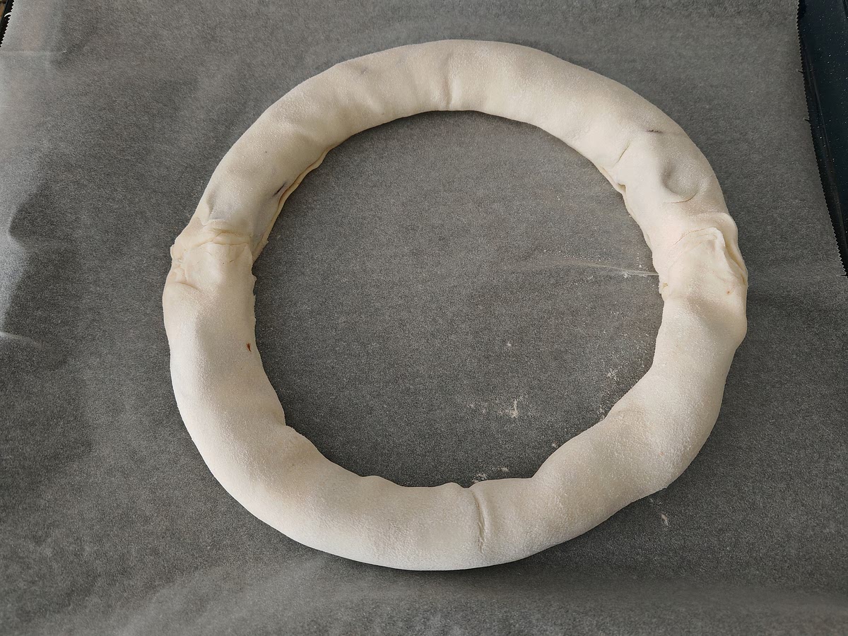 Enrollar la masa y presentarla en la bandeja del horno en forma circular (unir los bordes).