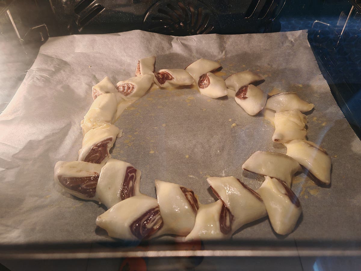 Con una tijera hacer unos cortes profundos y en diagonal a unos 3-4 cm. Separar cada cachito en sentido opuesto para hacer la corona. Con ayuda de un pincel huntar el huevo batido.