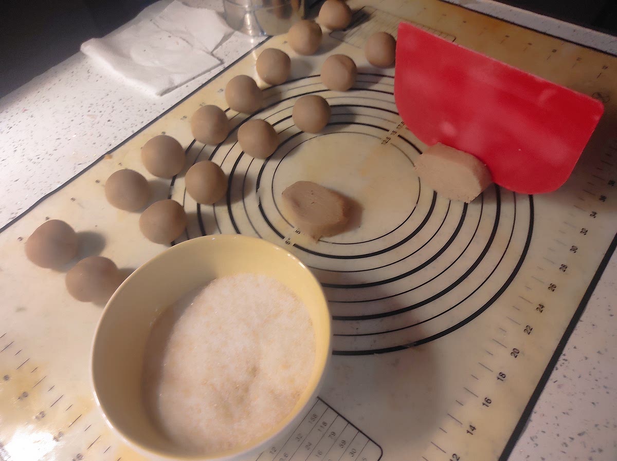 Bolear entre las palmas de las manos, rebosar cada una en un cazo de azúcar blanco granulados.