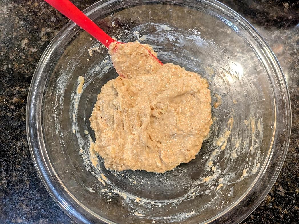In a medium bowl, mash the banana with a fork until smooth. Add in the nut butter, protein powder, baking powder, salt, and vanilla. Mix until combined with a silicone spatula. The "dough" should be very sticky