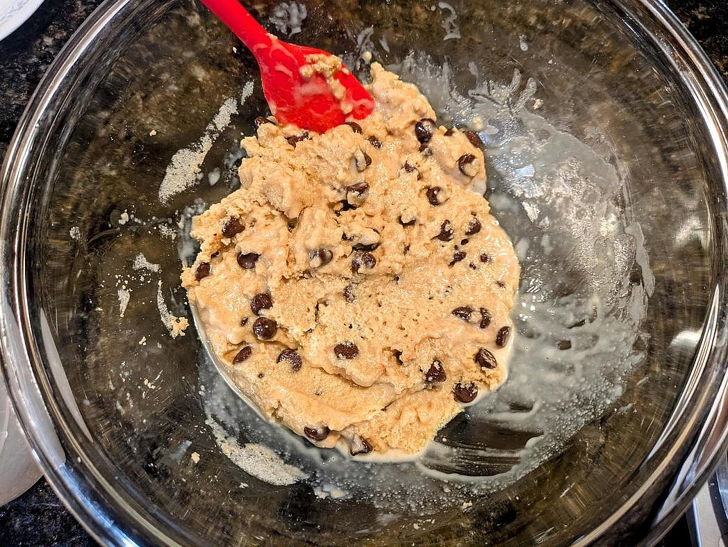 Melt your nut butter and oil in the microwave for about 45 seconds in a glass bowl. Stir in the honey, vanilla, and salt with a silicone spatula. Mix in the protein powder and almond milk until fully incorporated and slightly sticky. Chill the dough in the fridge for at least 15 minutes before folding in the chocolate chips