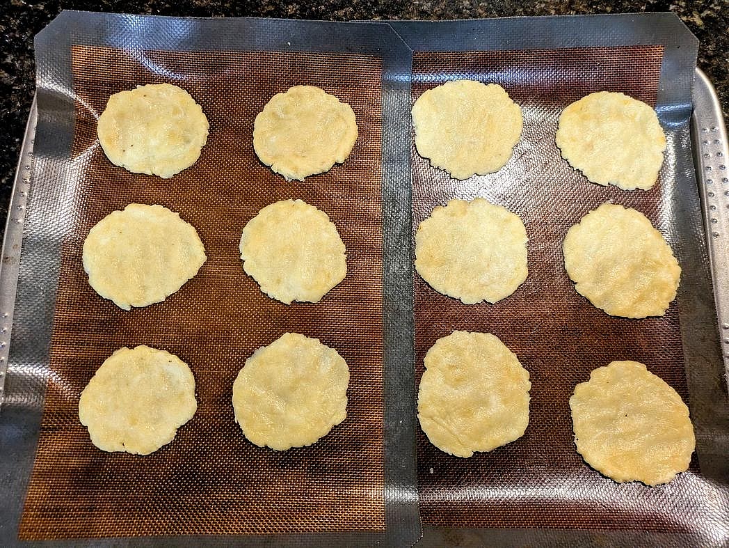 Scoop your dough into 12 equal sized pieces, about 27 g each, and roll into balls. Place on the cookie sheet, and flatten into a round and thin circle about 1/4" thick