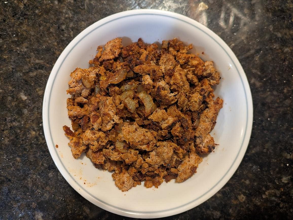 Here's an example meat filling for your empanadas. Heat a medium pan over medium heat with 1 tsp (5 g) olive oil. Finely dice half an onion, and add to the pan. Cook for about 5 minutes, or until transparent and lightly caramelized. Add 1/3 lb (151 g) 93% lean ground meat to the pan, and cook until browned and no longer pink. Season with 1 tsp (3 g) each of garlic powder, onion powder, paprika, and cumin, as well as 1/2 tsp (3 g) salt. Each empanada gets about 1 tbsp (12 g) of filling