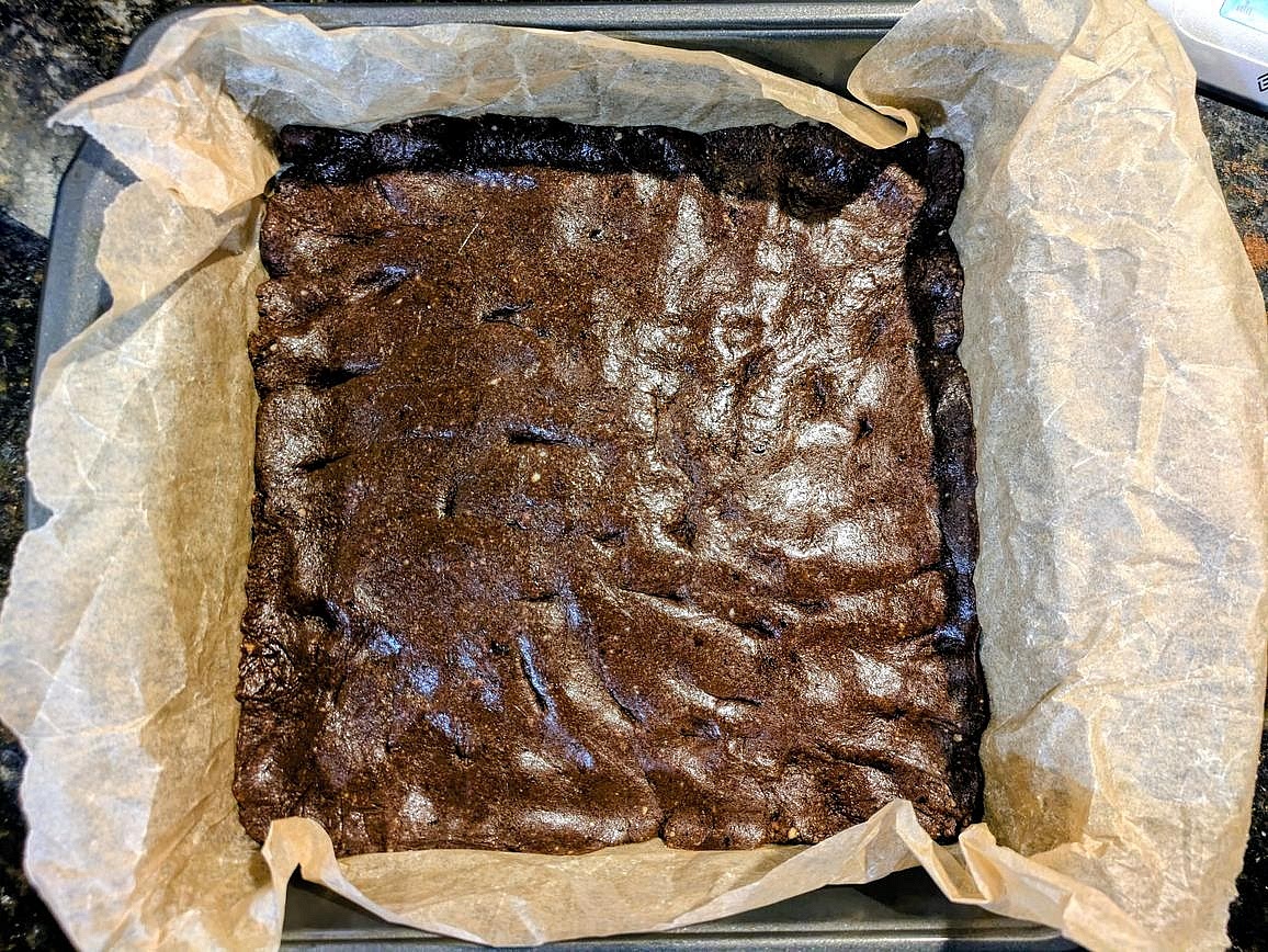 Line a 9" square baking pan with parchment paper. Using kitchen gloves to prevent sticking. evenly press the dough into all edges of the pan
