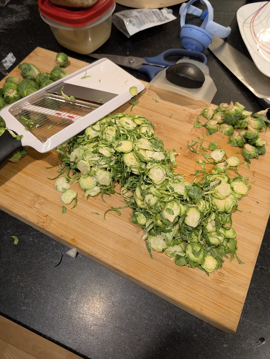 Begin by prepping your ingredients. Finely chop garlic, thinly slice onions, grate your Parmesan and use a mandolin to shave the brussel sprouts on the largest setting.