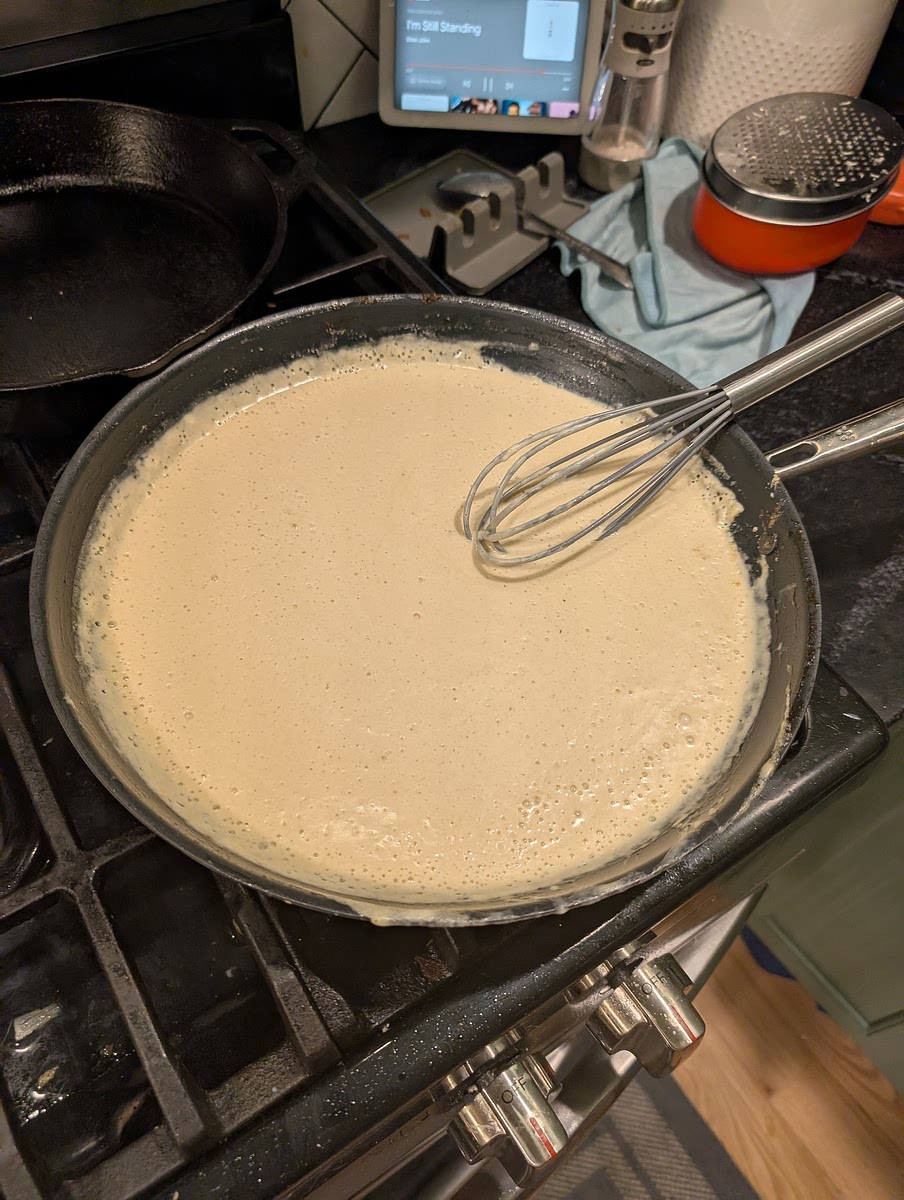 When onions are done set aside and use the skillet to prepare your garlic cream sauce. Add remaining butter to the pan and let foam, add garlic and saute until fragrant. Add flour and stir until a roux forms, cooking off the four. Add in heavy cream and remaining chicken stock. Stir to combine and let simmer until it begins to thicken. Off heat add Parmesan until combined.