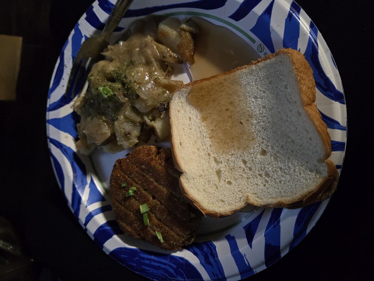 Serve salmon croquettes with potatoes and a slice of white bread on the side. Spoon gravy with onions over the pan-fried potatoes.