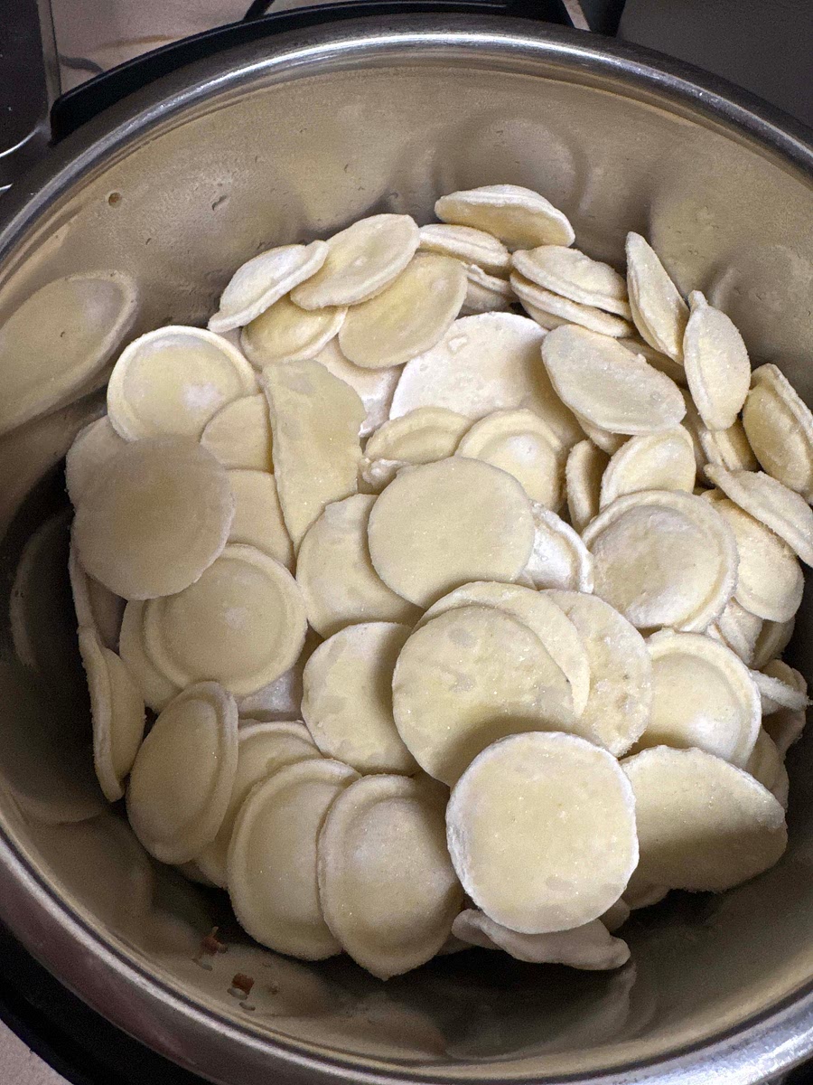 Layer the Ingredients leaving chicken and broth at the bottom (Do Not Stir!): Add the frozen ravioli on top of the chicken in an even layer.