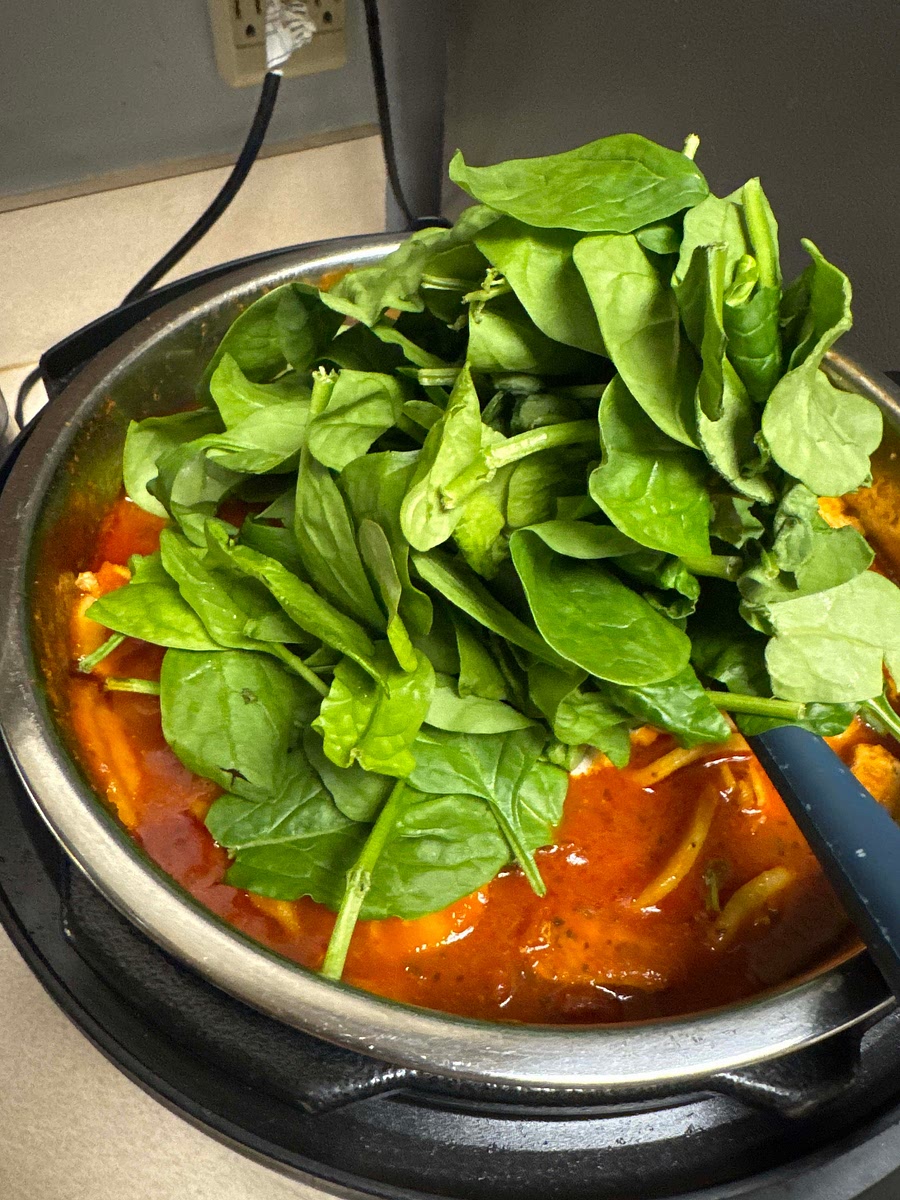 Turn the Instant Pot back on to Sauté (Low). Stir in heavy cream. Add the spinach in large handfuls. Stir continuously for 1-2 minutes. The spinach will wilt quickly, and the sauce will thicken into a rich, creamy consistency.