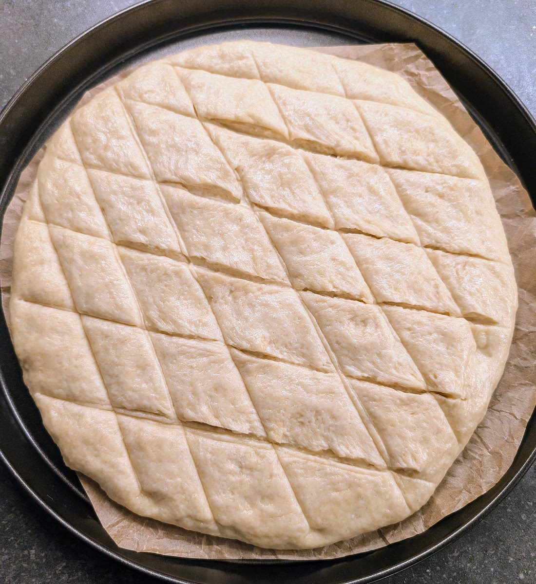 With a large knife, score the surface of the dough in the traditional diamond pattern. This will make the finished flatbread more attractive, and it will easily tear where it's scored, making diamond shaped pieces