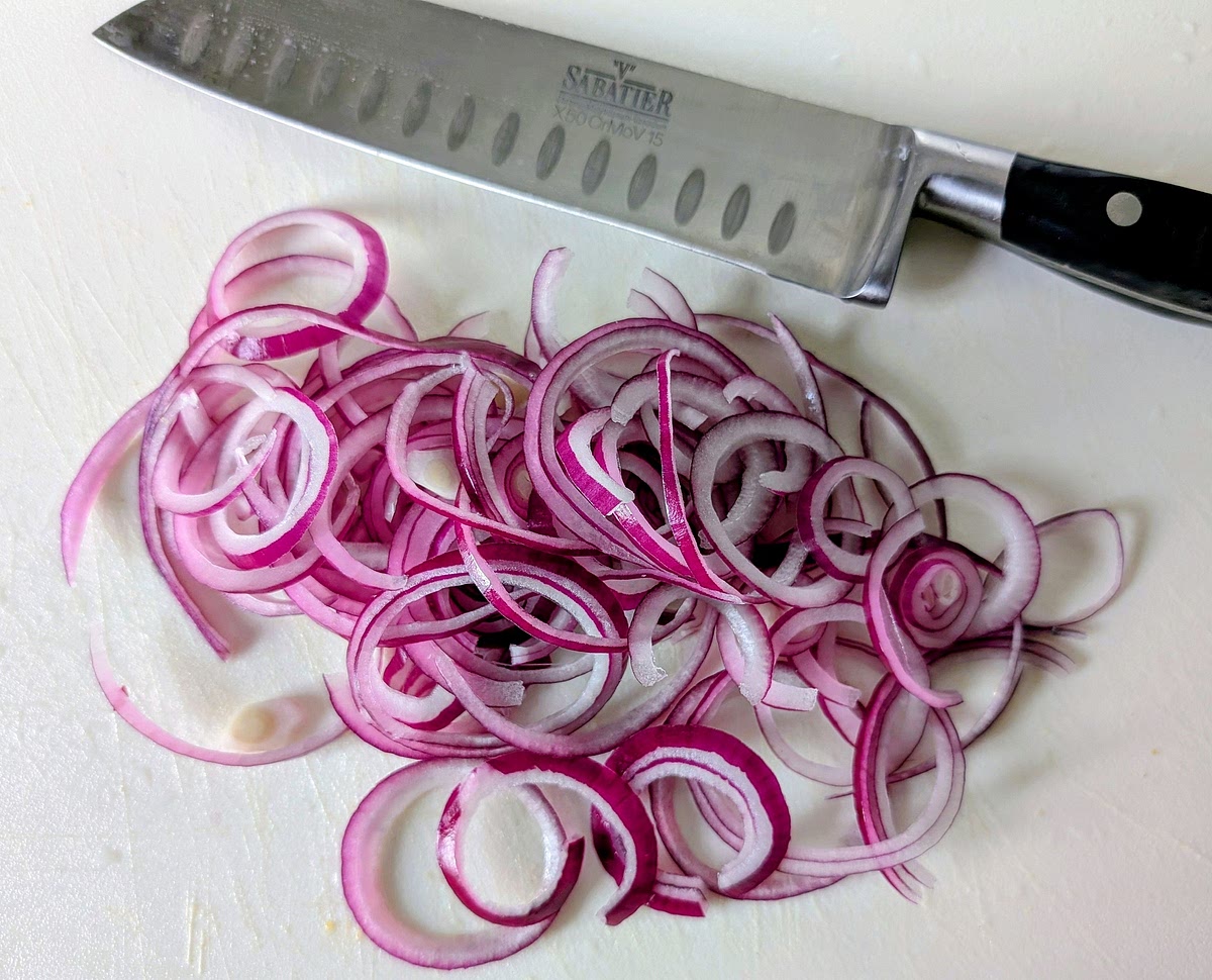 Thinly slice 1 medium red onion. Slices have to be as tin as you can, for the quick pickling to work.