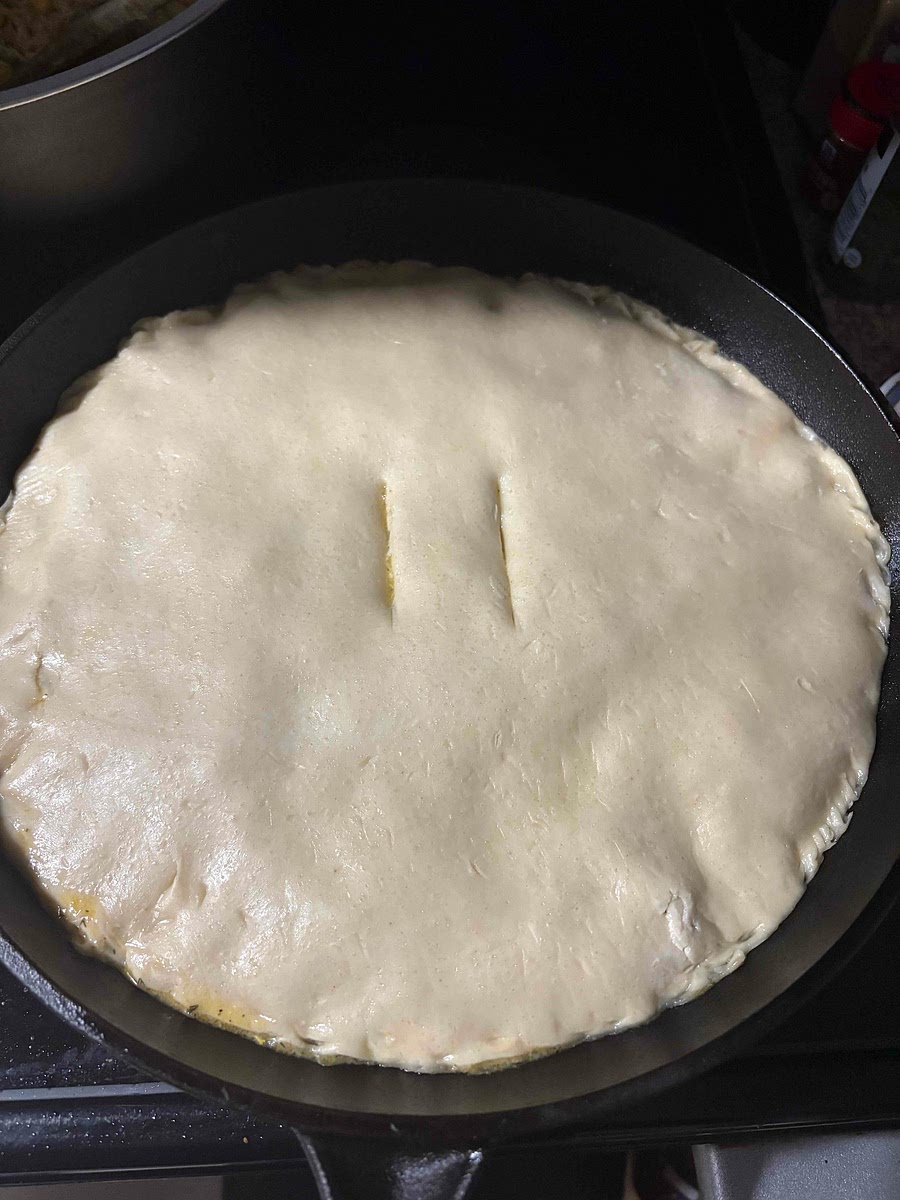 Add top pie crust crimping the edges if desired, cut two slits in the middle of the pie.