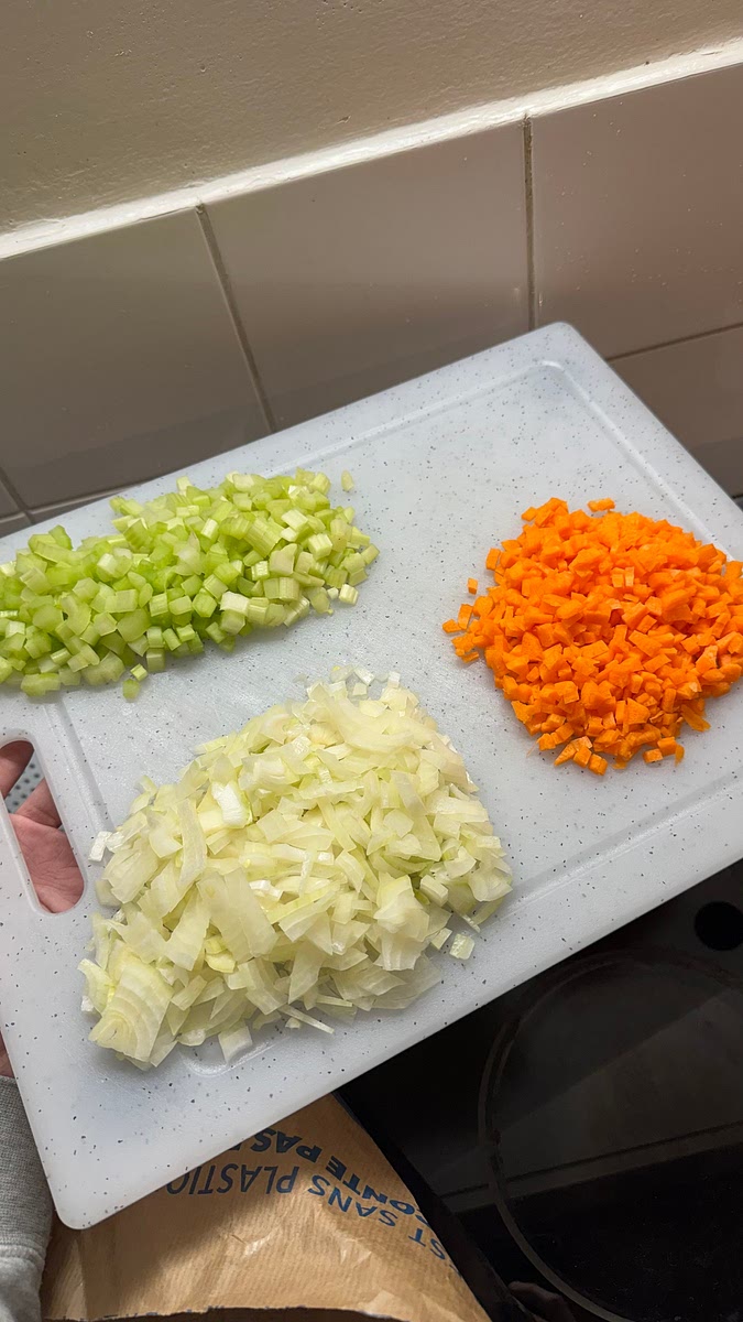 Retirer la peau des carottes et oignons, nettoyer les branches de céleri et ciseler le tout en petit dès (i.e. découper en brunoise).