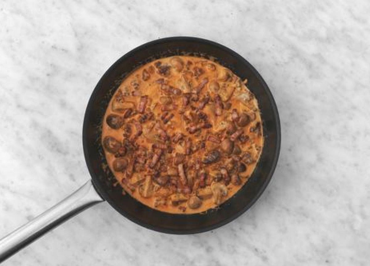 a) When the mince has browned, drain and discard any excess fat. Season with salt and pepper. IMPORTANT:
The mince is cooked when no longer pink in the middle. b) Add the mushrooms to the beef and stir-fry until browned, 3-4 mins. c) Lower the pan to medium heat, then add the garlic and tomato puree. Cook for 1 min. d) Stir through the gochujang paste, creme fraiche, chicken stock paste, sugar and water for the sauce (see pantry for both amounts). Simmer until thickened slightly, 3
-4 mins.