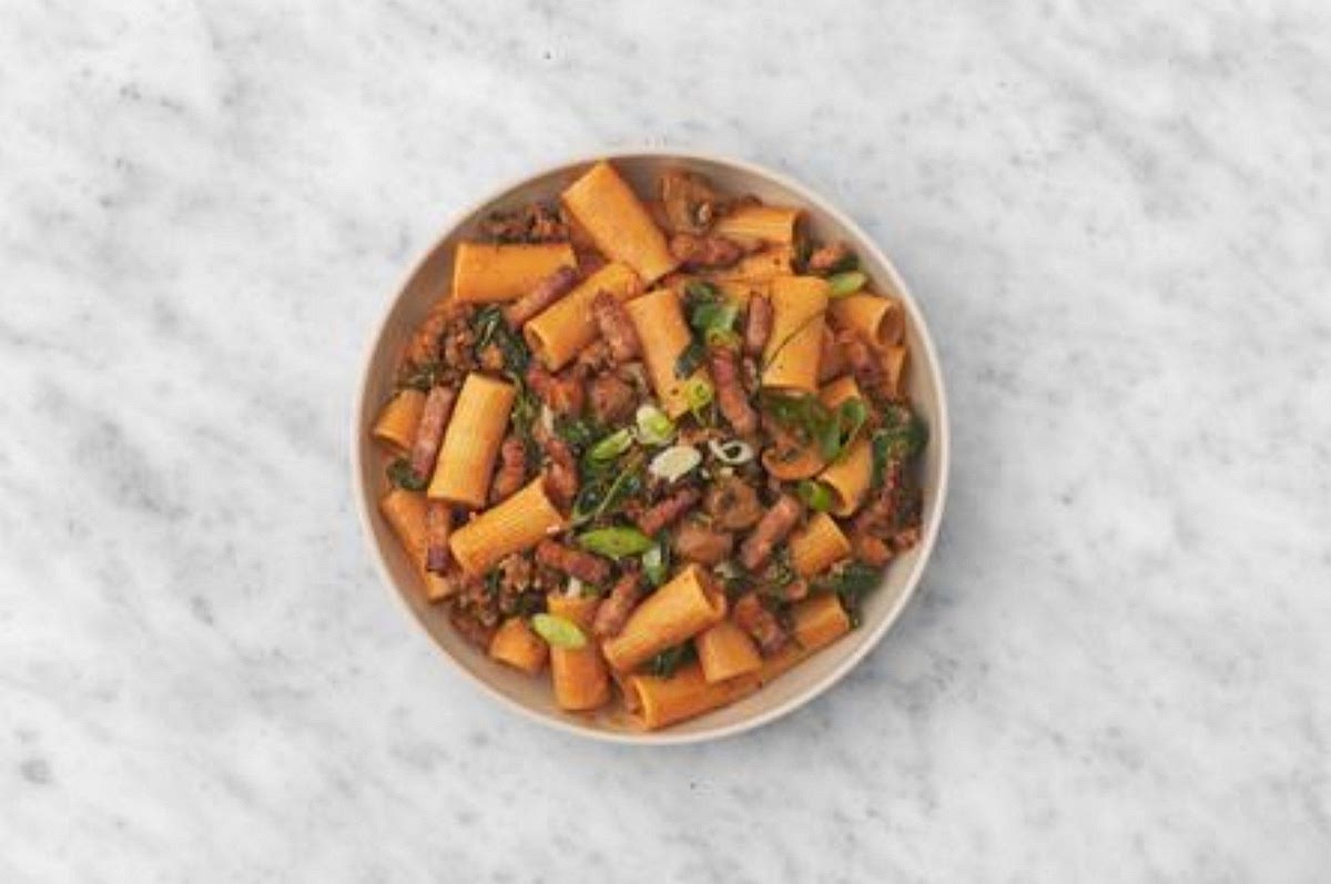 a) Share the creamy gochujang rigatoni between your bowls. b) Sprinkle over the spring onion to finish. Enjoy!