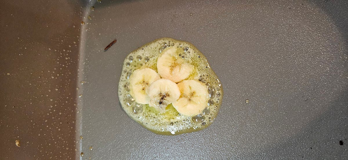 Mix all ingredients except banana. Light stir, leave lumpy. Butter an electric skillet and place sliced bananas on top then pour battet in a circle pattern over the bananas starting on the outside and filling in the middle. Cook til done. Top with maple syrup &/or powder sugar