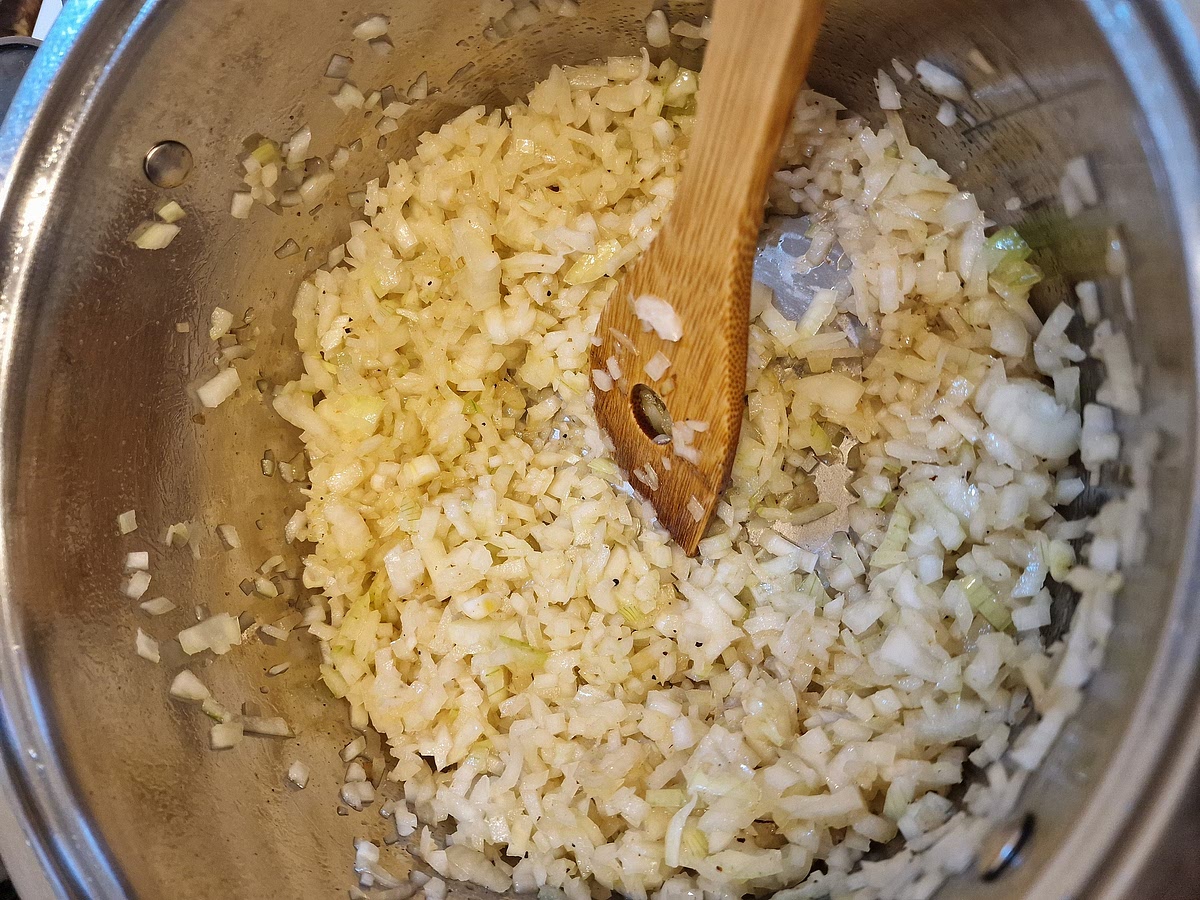 Put your seared chicken aside, deglaze the bottom of the pot with a splash of chicken broth (literally half a ladle), turn the heat all the way down and add the onion. Fry on low to medium heat until it's nice and soft. The lower the heat and the longer you fry the onion like this, the better the result. Salt your onion, it gives the dish depth and helps break down the onion a bit faster.