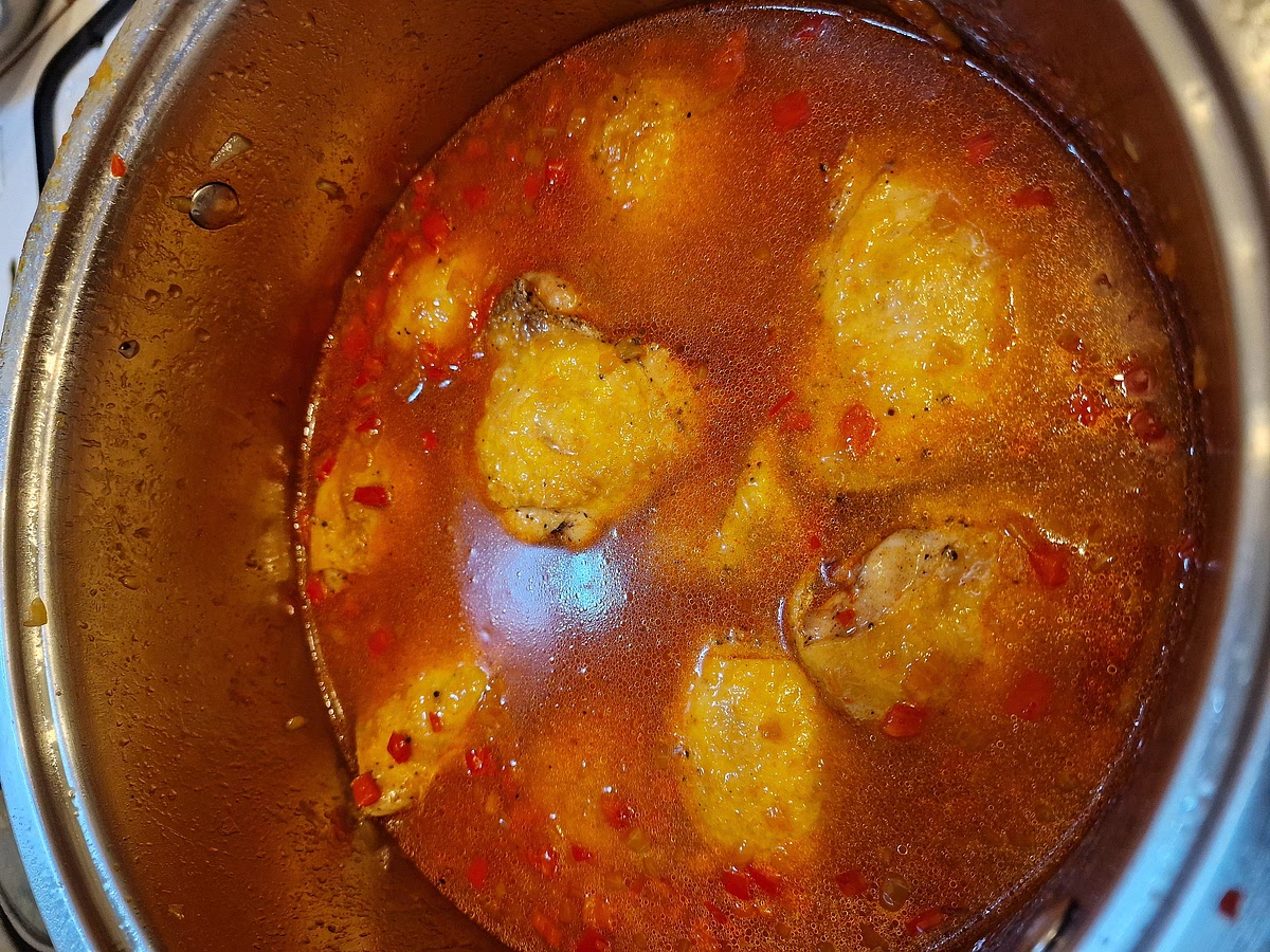 Cover everything with chicken broth. The amount depends on how thick you want the final sauce. If you're aiming for a bit thicker sauce, use less stock. If you want the sauce to be more watery, use more stock. After frying, my onion and peppers amounted to around 1 kg so I used equal part of the broth, 1 litre. Just so the meat was covered with it. When adding the broth, shake the whole pot a little bit so everything mixes and settles. Bring it to boil, cover it and simmer on low heat for 30-40 minutes.