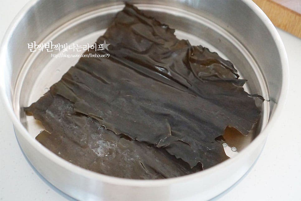 준비한 재료를 찜기에 담아줍니다. 먼저 바닥에 다시마를 깔아주는데요. 냄비 크기에 따라 크기를 조절해 주세요. 다시마는 흐르는 물에 헹군 뒤 올려주세요. 전복이 다시마나 미역을 먹기 때문에 다시마와 찌면 본연의 감칠맛이 더 좋습니다. 그 위로 손질한 재료를 올려줍니다. 무를 올려 덮어줍니다.