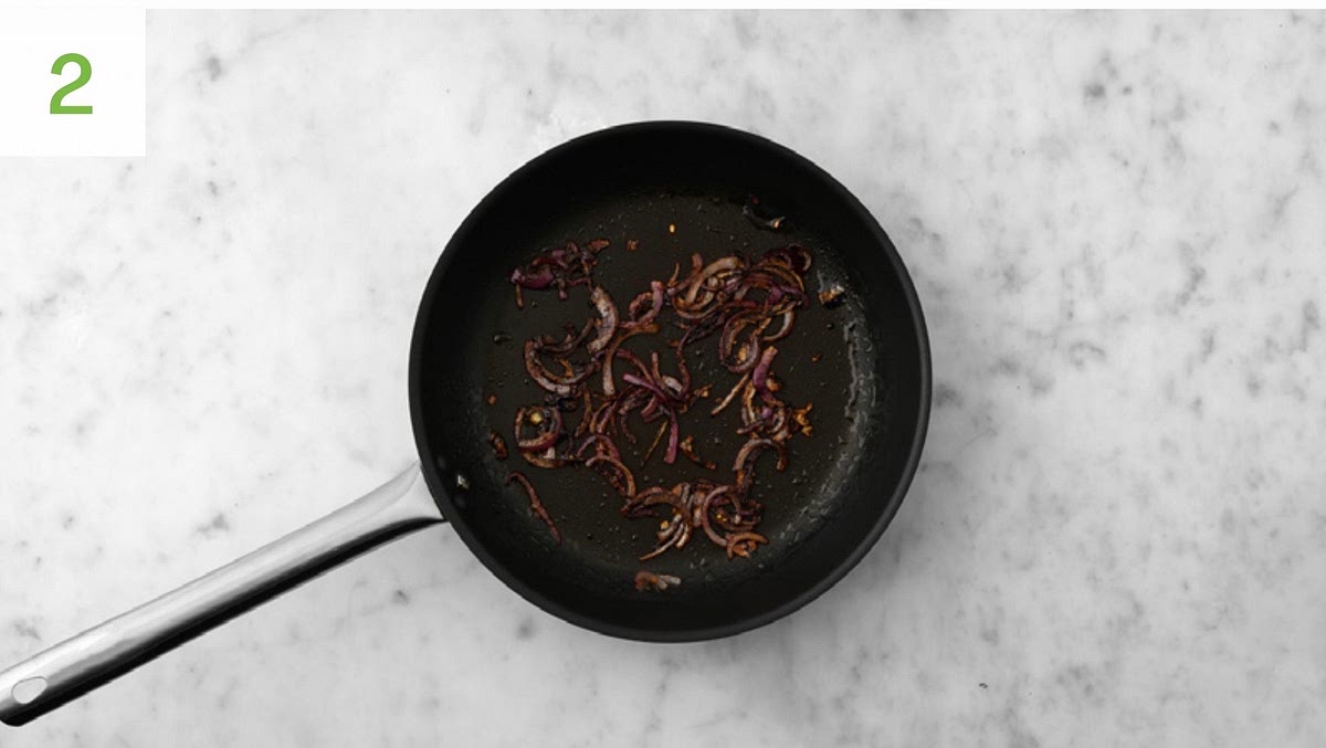 While everything bakes, halve, peel and thinly slice the
red onion. Heat a drizzle of oil and a knob of butter (if you have any) in a large frying pan on medium heat. Once hot, add the onion, season with salt and pepper and fry, stirring occasionally, until golden and softened, 8-10 mins. Add the sugar for the onions (see pantry for amount) and cook until caramelised, 1-2 mins more. While the onion cooks, grate the Cheddar. Halve the baby plum tomatoes.