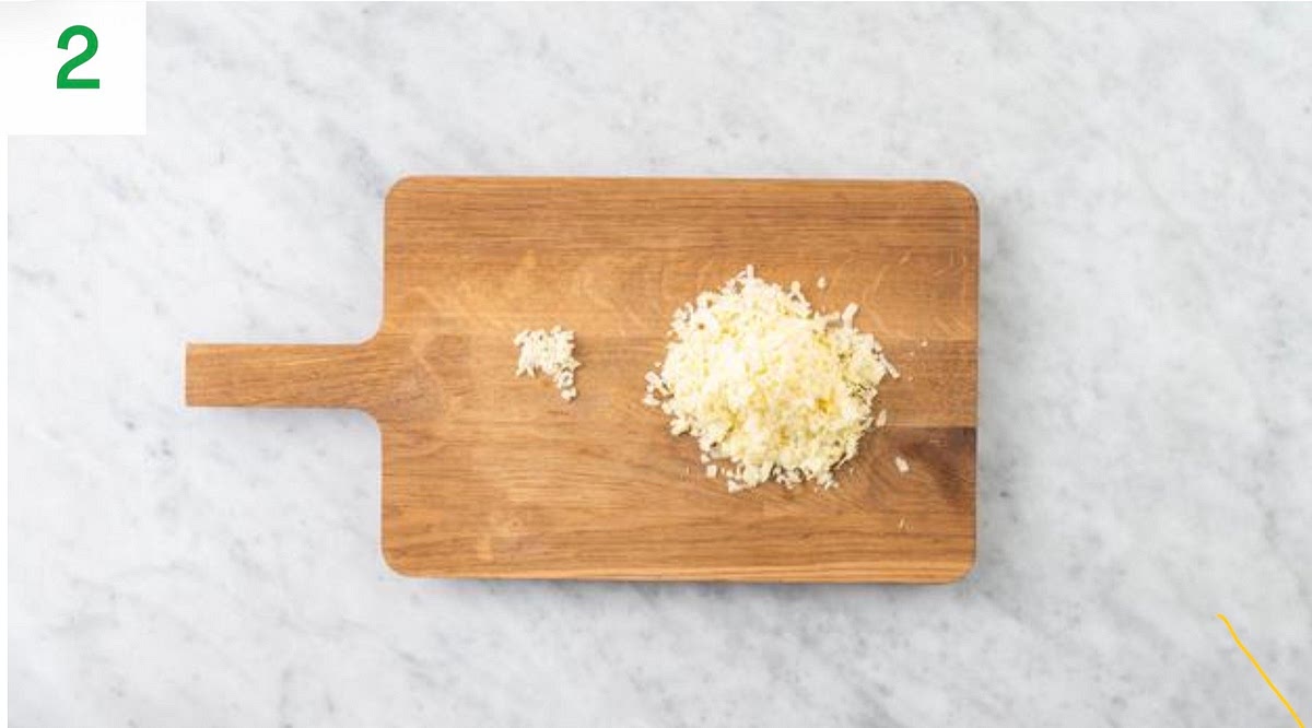 a) Meanwhile, peel and grate the garlic (or use a garlic press). b) Grate the cheese. c) Once the pork is cooked, drain and discard any excess fat, then season with salt and pepper.
