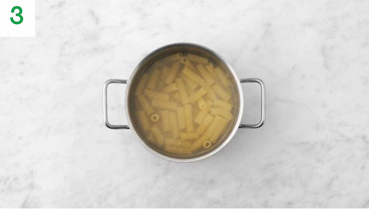 a) Meanwhile, add the rigatoni to the boiling water and bring back to the boil. b) Cook until tender, 12 mins.