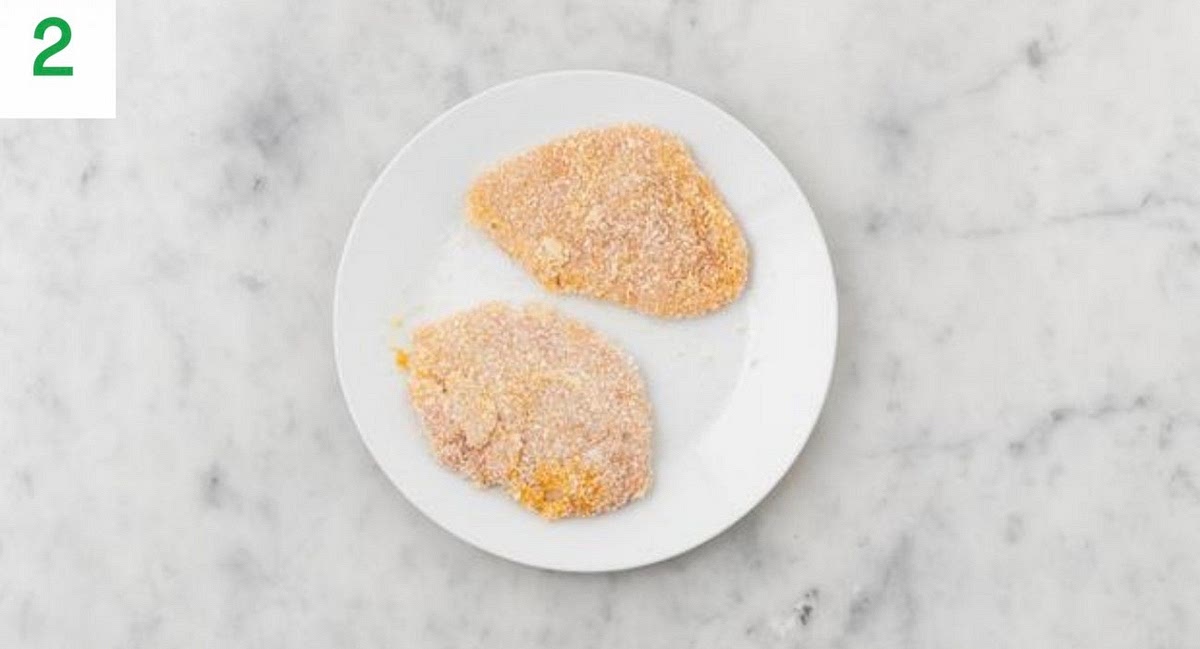 Meanwhile, sandwich each chicken breast between two pieces of baking paper or cling film. Pop onto a board,
then bash with a rolling pin or the bottom of a saucepan
until it’s 1-2cm thick. Season with salt and pepper. TIP:Notice a stronger smell from your chicken? Don’ t worry,
this is normal due to packaging we use to keep it fresh.
Crack the egg (see pantry for amount) into a medium
bowl and whisk. In another medium bowl, combine the
breadcrumbs, Central American style spice mix and the
salt (see pantry for amount).
Dip the chicken into the egg and then the breadcrumbs,
ensuring it's completely coated. Transfer to a clean
plate.