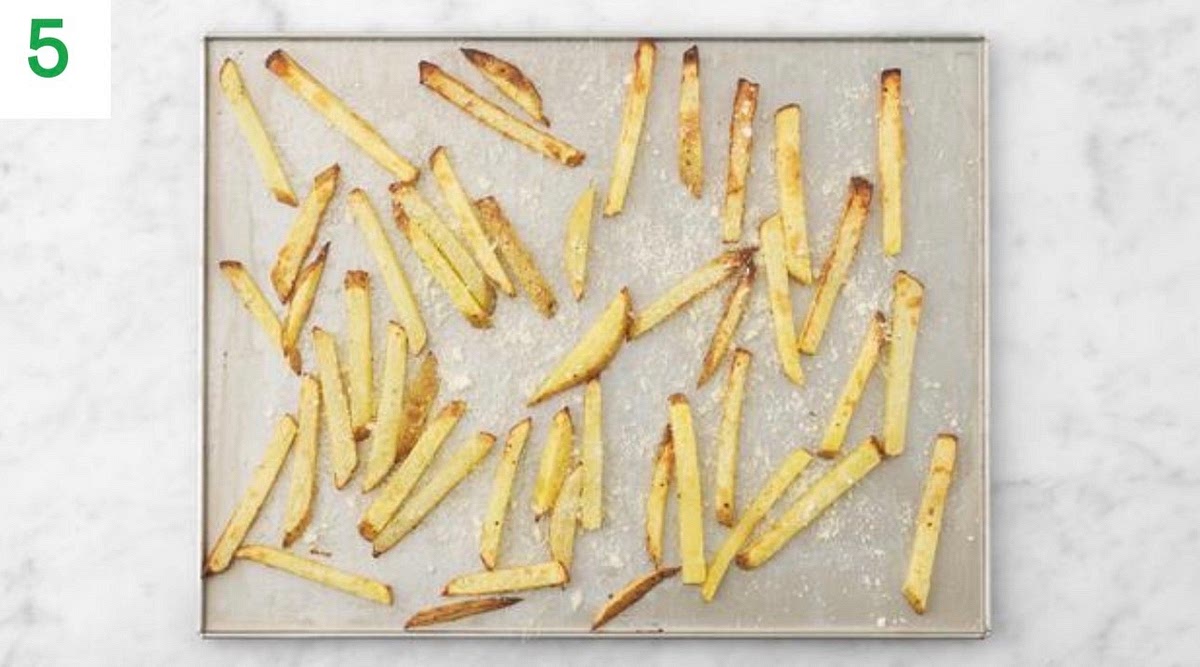 When the chips have 5 mins left, sprinkle over half the cheese and return to the oven to melt.
Pop the tortillas (3 per person) into the oven to warm through, 1-2 mins.