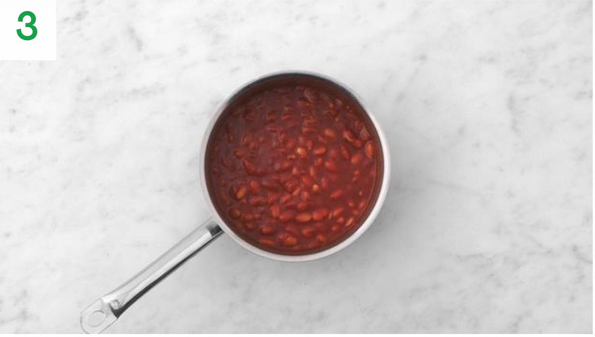 Meanwhile, drain and rinse the butter beans in a sieve.
Pop a large saucepan on medium-high heat and add the passata, butter beans, red wine stock paste, sugar and water for the sauce (see pantry for both amounts).
Stir together and bring to a boil, then reduce the heat.
Leave to gently simmer until slightly thickened, 5-6mins, then cover and set aside for later.
In the meantime, halve the ciabatta.