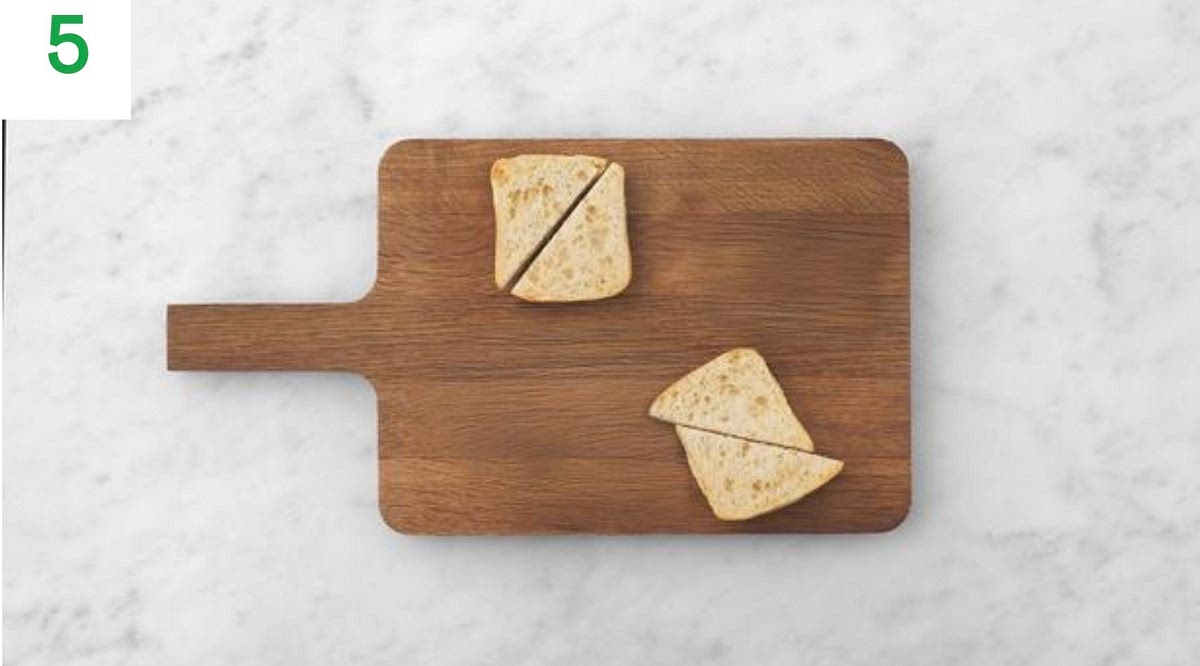 Meanwhile, halve the ciabatta.
If you're using the toaster, toast the ciabatta in your toaster until golden.
If you're using the oven, pop them into the oven to warm through, 2-3 mins.
Once toasted, drizzle over some oil, then cut the ciabatta halves diagonally into triangles.