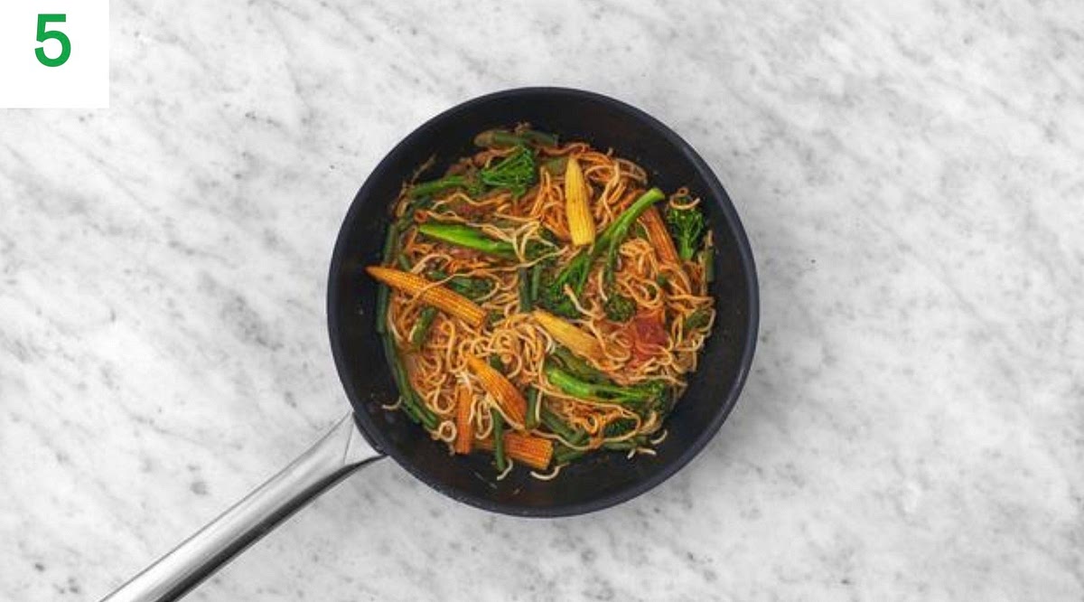 Add the peanut sauce to the pan and stir well until combined.
Stir through the cooked noodles, green beans and broccoli to coat them in the sauce, then bring to the boil. Simmer until slightly thickened, 1-2 mins.
Once thickened, remove from the heat.
Add a good squeeze of lime juice and a splash of water if you feel it needs it.