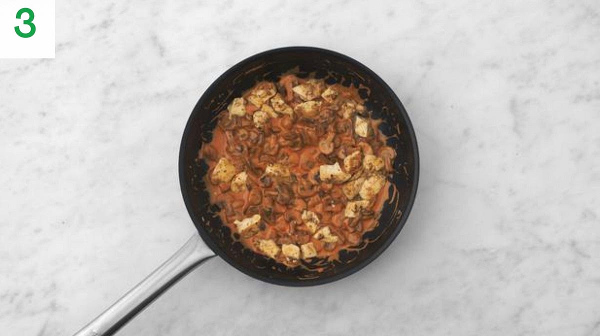 Meanwhile, finely chop the prunes into 1cm pieces.
Peel and grate the garlic (or use a garlic press).
Add the garlic to the chicken and veg for the final min of cooking and stir-fry until fragrant.
Pour in the water for the sauce and bring to a boil. Stir in the red wine jus paste, then reduce the heat to medium-high. TIP: If your red wine jus paste has hardened, pop it in a bowl of hot water for 1 min.