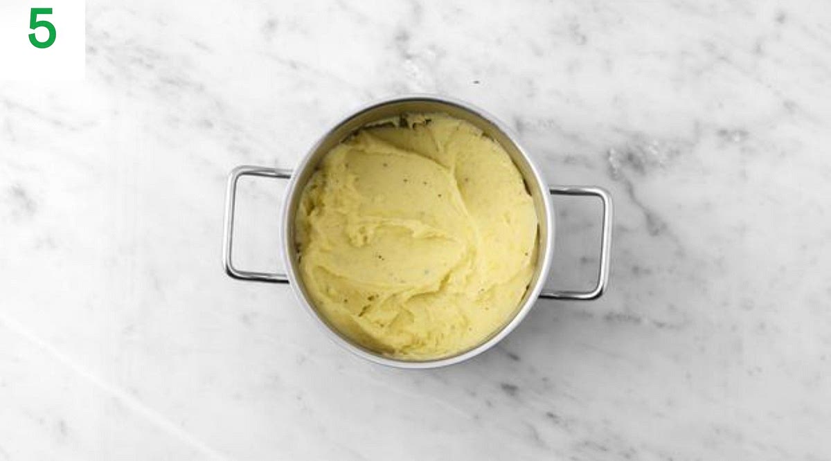 Meanwhile, once the potatoes are cooked, drain in a colander and return to the pan, oﬀ the heat. Add a knob of butter and a splash of milk (if you have any) and mash until smooth.
Season with salt and pepper. Cover with a lid to keep warm.
When the sauce has thickened, add the peas. Stir in the butter (see pantry for amount) until melted.
Add a splash of water if it's a little too thick.