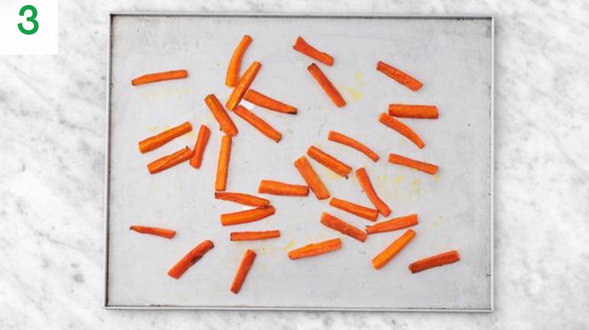 While the potatoes roast, trim the carrots, (no need to peel). Chop into roughly 1cm wide, 5cm long batons.
Place onto a baking tray, drizzle with oil and the honey, then season with salt and pepper. Toss to coat, then spread out in a single layer.
Roast on the middle shelf of your oven until tender, 20-25 mins. Turn halfway through.