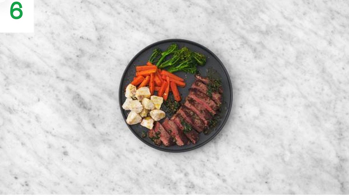 When everything's ready, slice the lamb steaks in half and transfer to your plates.
Serve with the roast potatoes, carrots and broccoli alongside. Spoon the salsa verde over the lamb to finish.