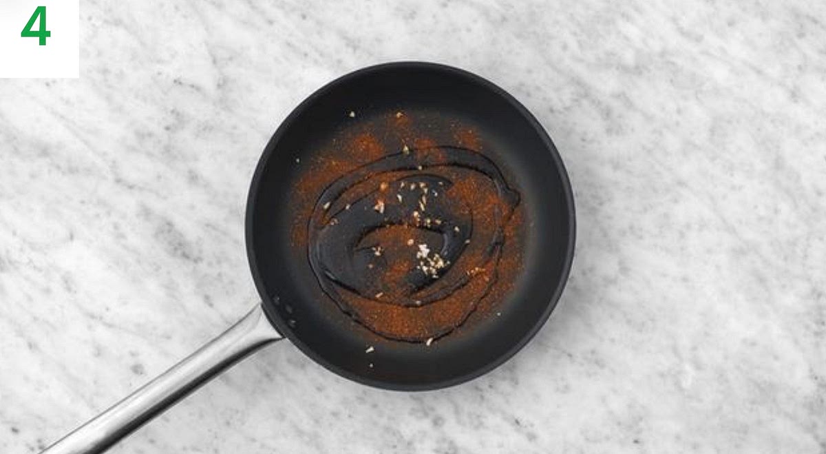 About 5-10 mins before the ribs are ready, spoon over the char siu paste and return to the oven for the remaining time.
Meanwhile, heat a drizzle of oil in a large frying pan on medium-high heat.
Add the Chinese Five Spice, garlic, hoisin sauce, sugar and water for the sauce along with the remaining soy sauce to the pan. Simmer until thickened slightly, 1-2 mins.