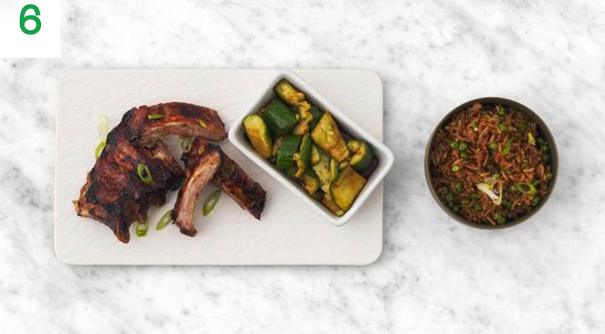 When everything's ready, share the ribs, hoisin fried rice and smacked cucumber in separate serving bowls.
Sprinkle over the spring onion over the ribs and rice to finish.