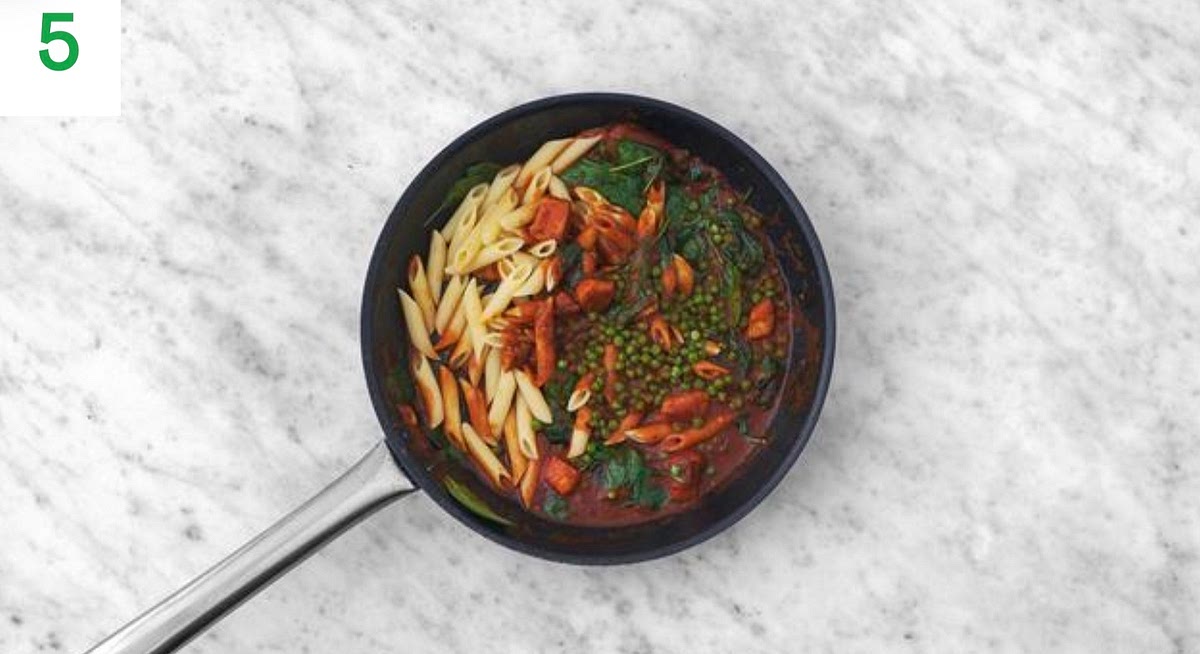 Once the sauce has thickened, add the spinach to the pan a handful at a time until wilted and piping hot, 1-2mins.
Stir through the peas, cooked pasta and butter and half the cheese.
Heat until the pasta is piping hot and the butter has melted, 1-2 mins.