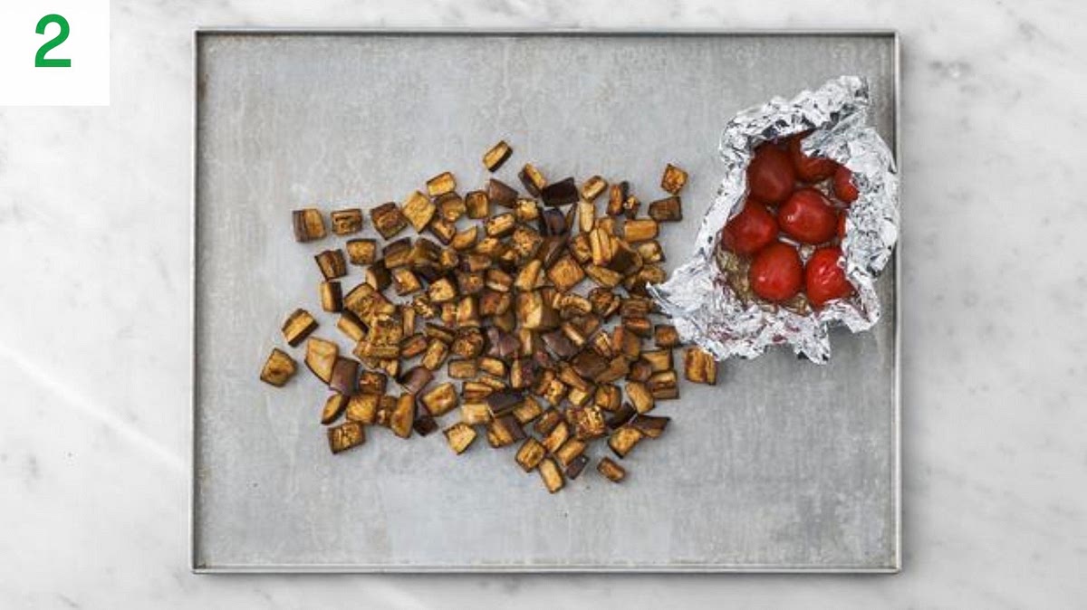 Pop the tomatoes onto a piece of foil with a drizzle of oil. Season with salt and pepper.
Fold the foil, sealing on all sides to create a parcel.
Place the tomato parcel onto the aubergine tray.
When the oven is hot, roast on the top shelf until soft and golden, 17-18 mins. Turn the aubergine halfway through.