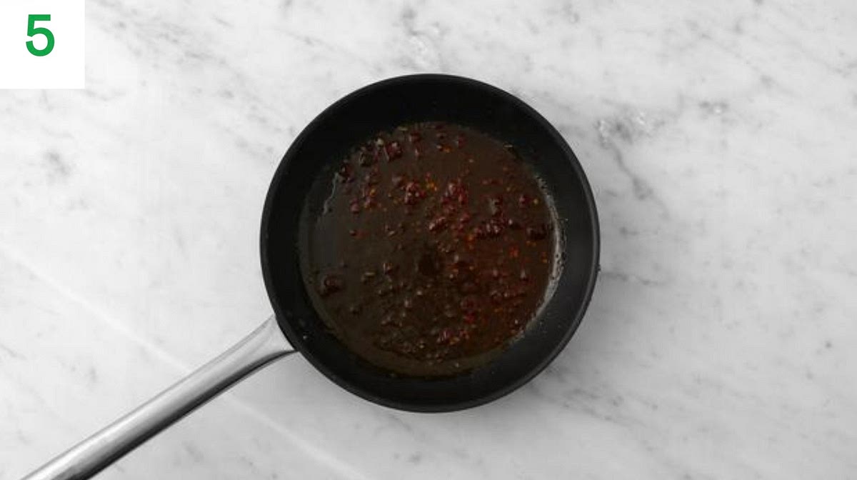 While everything’s in the oven, return the (now empty) frying pan to medium heat (no need to clean).
Add the water for the glaze and chicken stock paste. Bring to a boil, ten reduce the heat and simmer for 1-2 mins.
Add the red pepper chilli jelly and stir well to combine (use a whisk if necessary). Simmer until thickened and glossy, 3-4 mins, then remove from the heat.