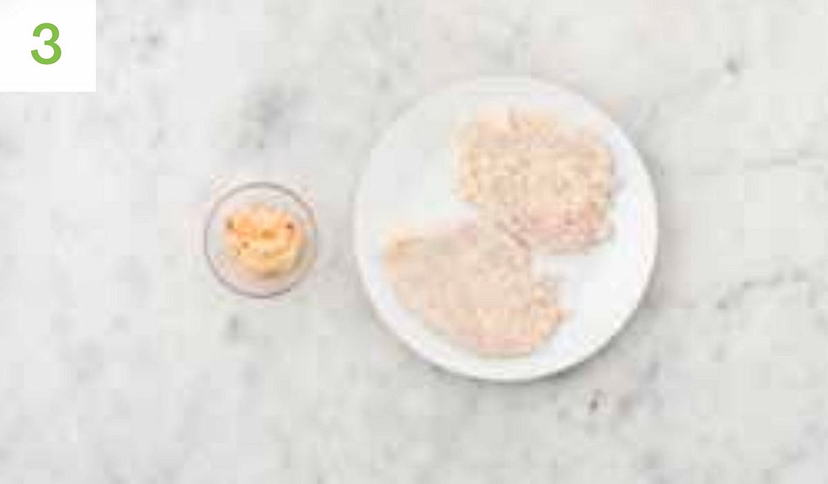 Sandwich each chicken breast between two pieces of mă baking paper or cling film. Pop onto a board, then give it a bash with the bottom of a saucepan until it’s 1-2cm thick. Pop the panko breadcrumbs into a medium bowl or plate and season with salt and pepper. In another medium shallow bowl, mix together the cornflour and water for the crumb. Season with salt and pepper, then whisk until well combined. Dip the chicken breasts into the cornflour mixture, then the breadcrumbs, ensuring they are completly coated. Then pop the chicken onto a plate.