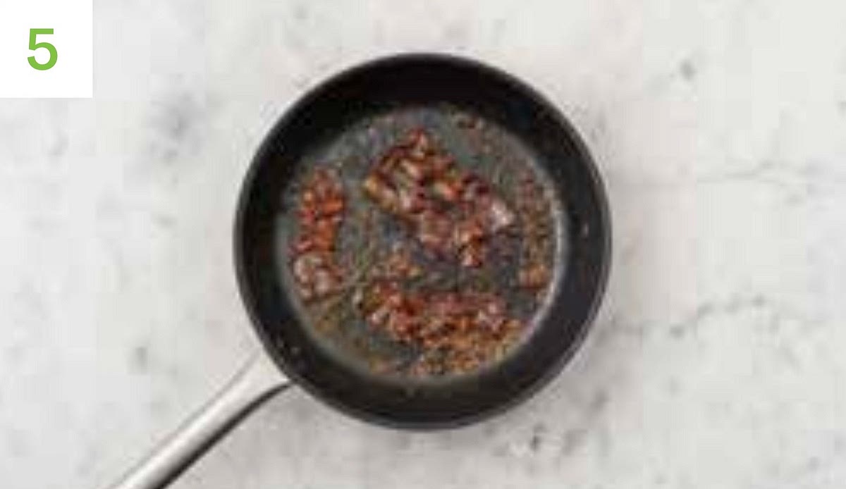 Drain the oil from your pan and pop back on medium-high heat. Lay in the bacon rashers and fry until crispy brown, 3-4 mins on each side.
Add the butter, garlic, and remaining honey to the pan and let it melt. Coat the bacon n, then remove from the heat.