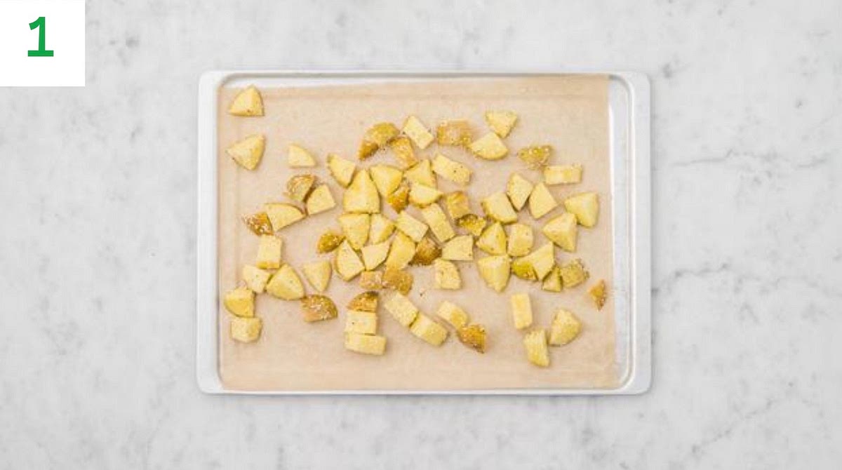 Preheat your oven to 220°C/200°C fan/gas mark 7.
Chop the potatoes into 2cm chunks (no need to peel).
Pop the chunks onto one side of a large baking tray.
Drizzle with oil and sprinkle over the sesame seeds.
Season, then toss to coat. Spread out in a single layer.
TIP: Use two baking trays if necessary.
When the oven is hot, roast the potato chunks on the top shelf until golden, 30-40 mins. Turn halfway through.