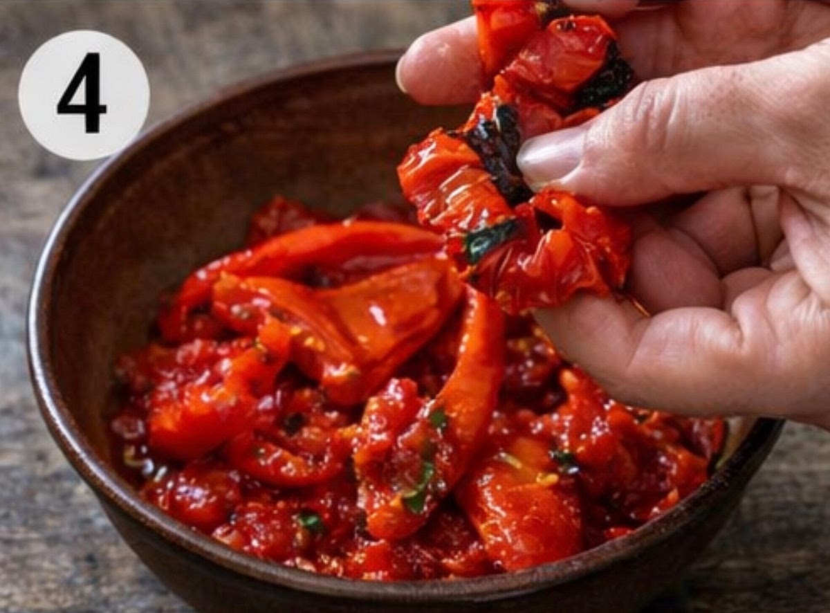 Remove the seeds from the peppers and tear them into strips, adding them to the tomatoes.
