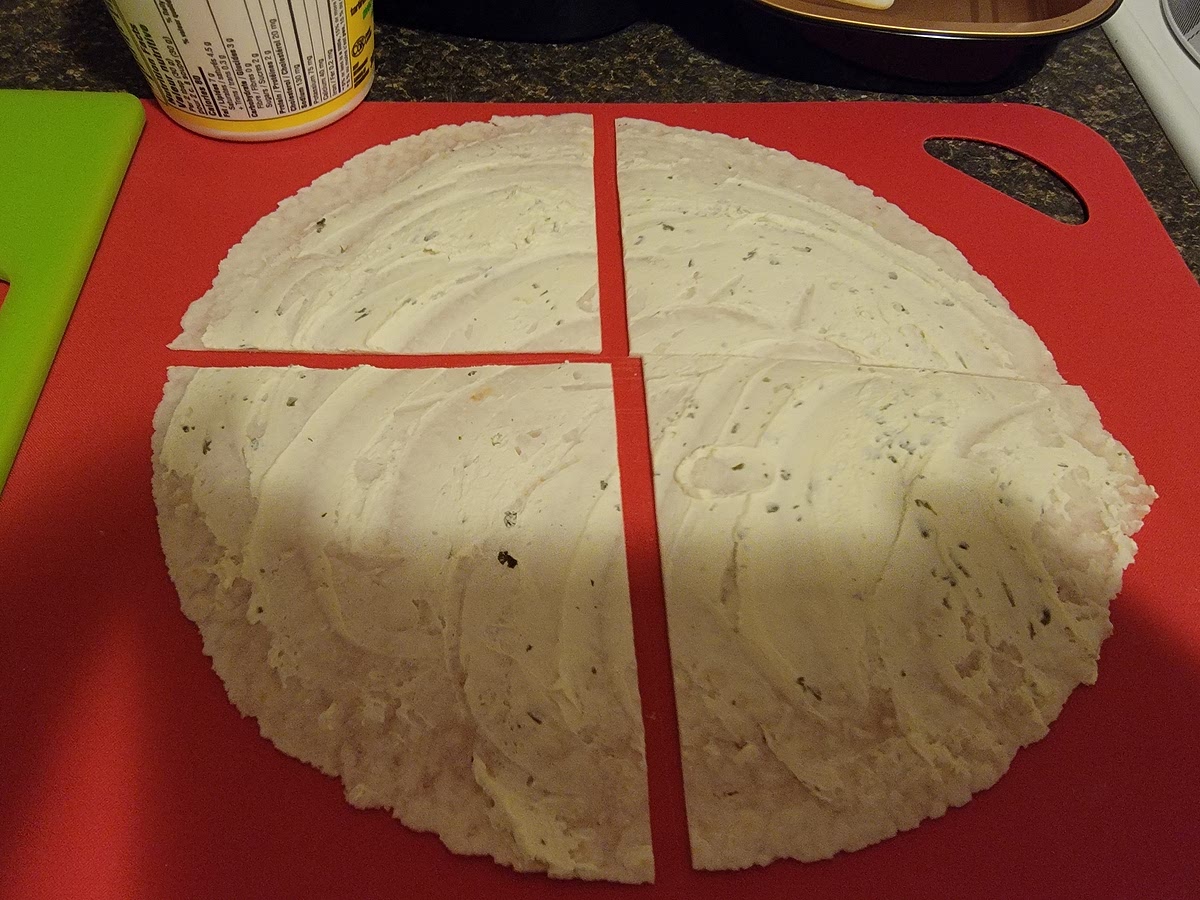 Cut the large tortilla with cream cheese into quarters.